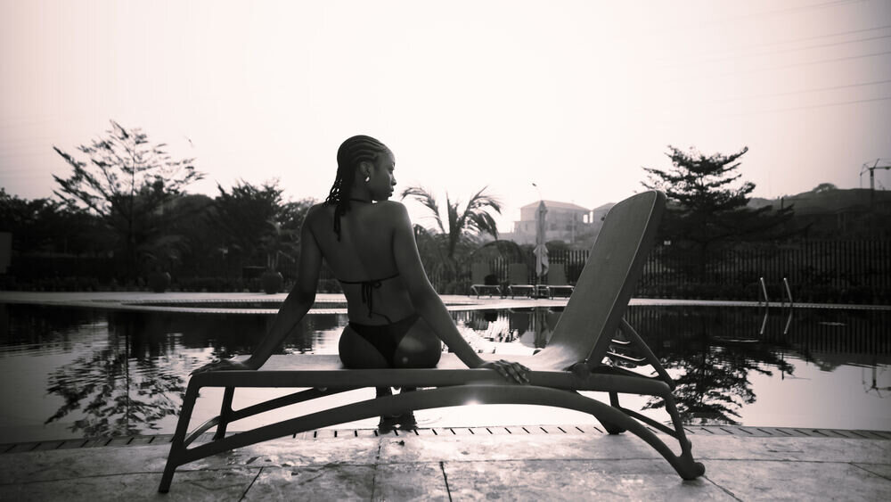 Woman on a poolside lounger in muted light